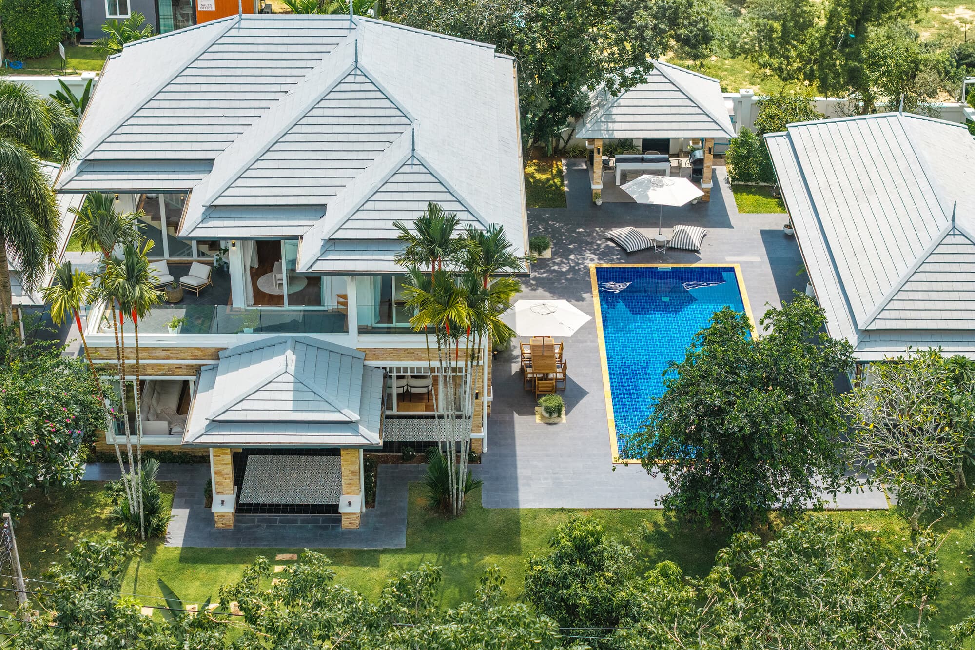 Aerial daytime view of Villa Bussaba roofs, garden, terrace, and pool