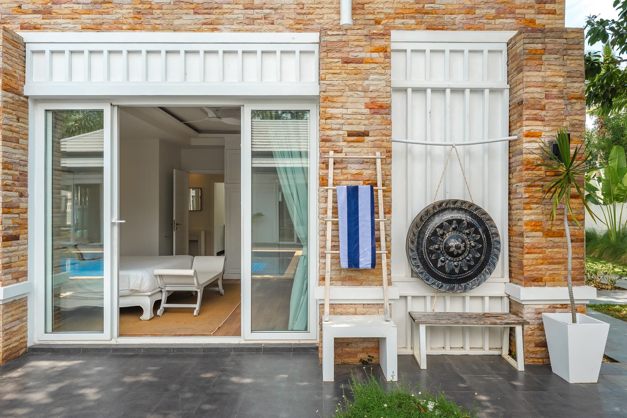 Guest room terrace with sliding doors, towel ladder, and decorative gong