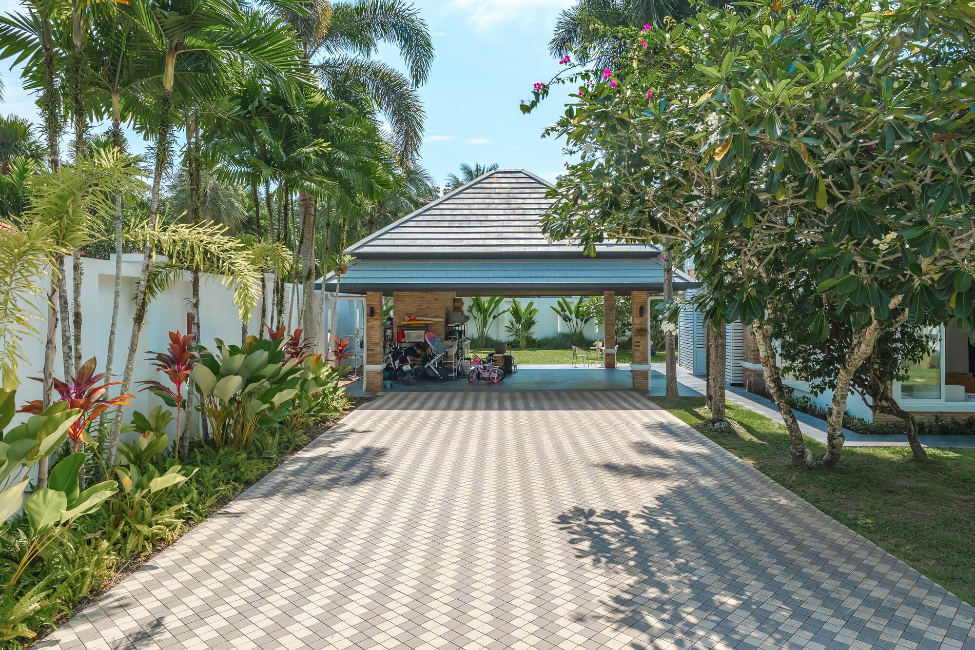 Tropical driveway leading to the covered parking and villa grounds